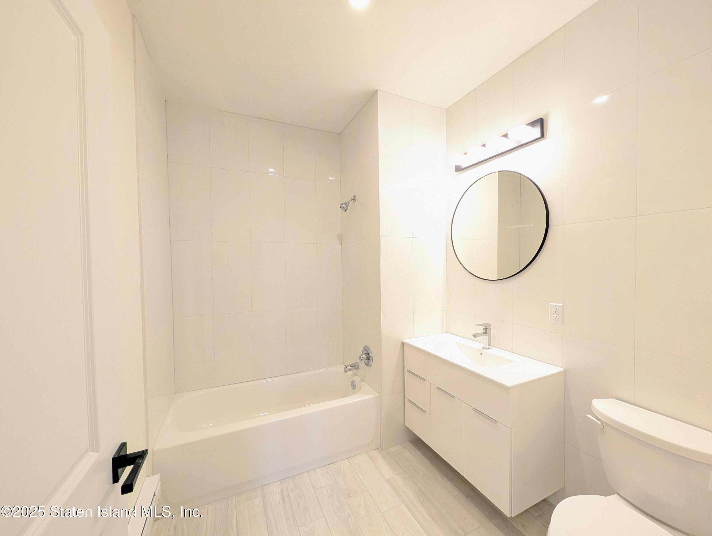 3865 Amboy Road, Unit 4B Staten Island, NY 10308 - Photo 6 of 15 a bathroom with a sink a toilet and a mirror