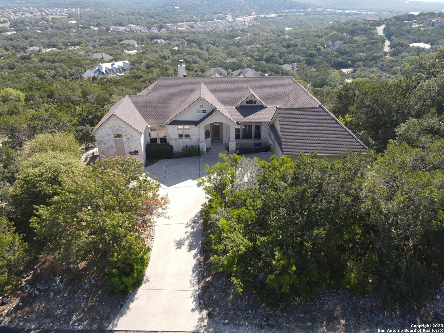 an aerial view of a house with a yard and lake view