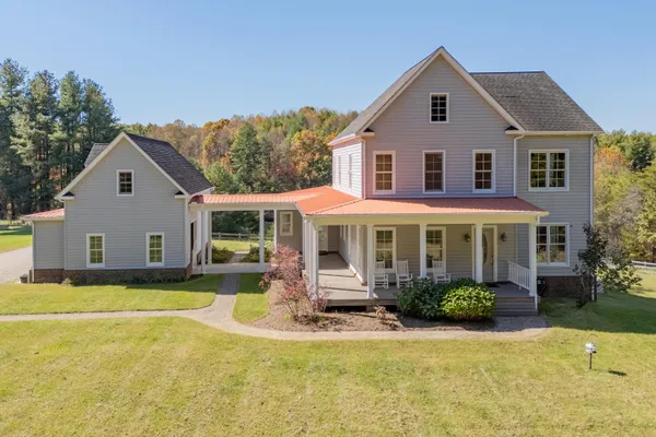 a view of a house with backyard sitting area and porch