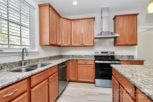 a kitchen with granite countertop a sink stove and cabinets