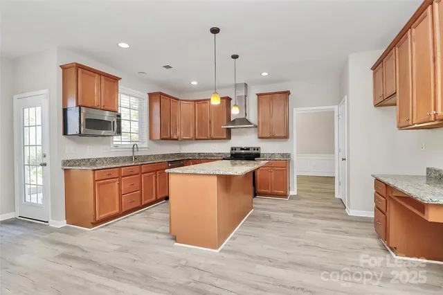 a large kitchen with stainless steel appliances granite countertop a stove a sink dishwasher and a refrigerator