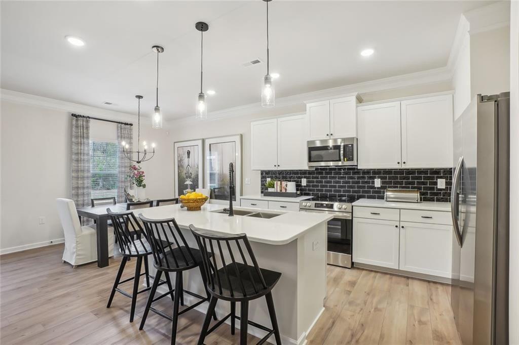 10 Southbend Court Rome, GA 30165 - Photo 10 of 25 a kitchen with a dining table chairs wooden floor cabinets appliances and a window