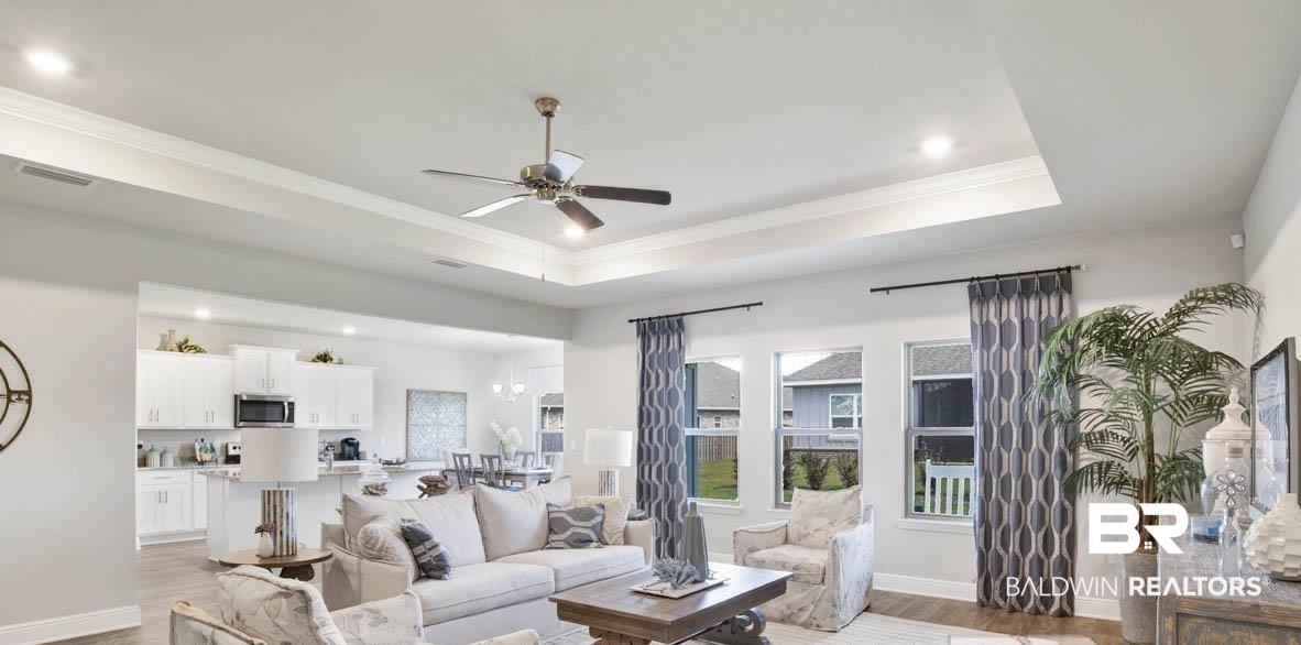 500 Huller Avenue Fairhope, AL 36532 - Photo 2 of 28 Living room with wood-type flooring, a tray ceiling, ceiling fan, and ornamental molding