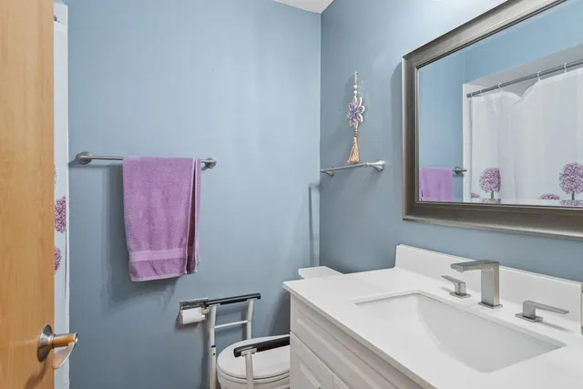 a bathroom with a sink vanity mirror and toilet