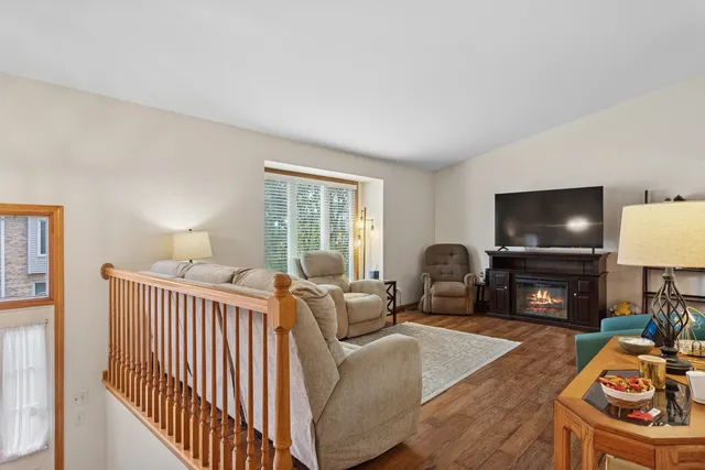 a living room with furniture a flat screen tv and a window