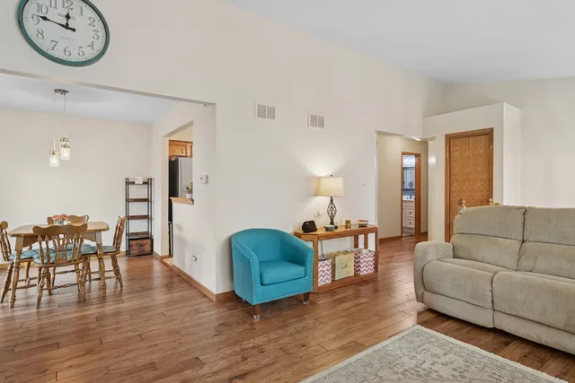 a living room with furniture a wooden floor and a chandelier