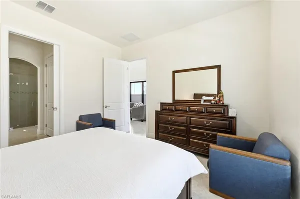a bedroom with a bed and dresser with mirror