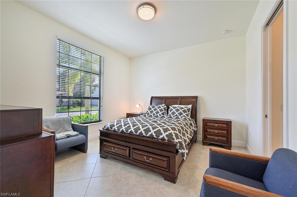 1326 Kendari Terrace Naples, FL 34113 - Photo 13 of 37 a bedroom with a bed and a couch with window