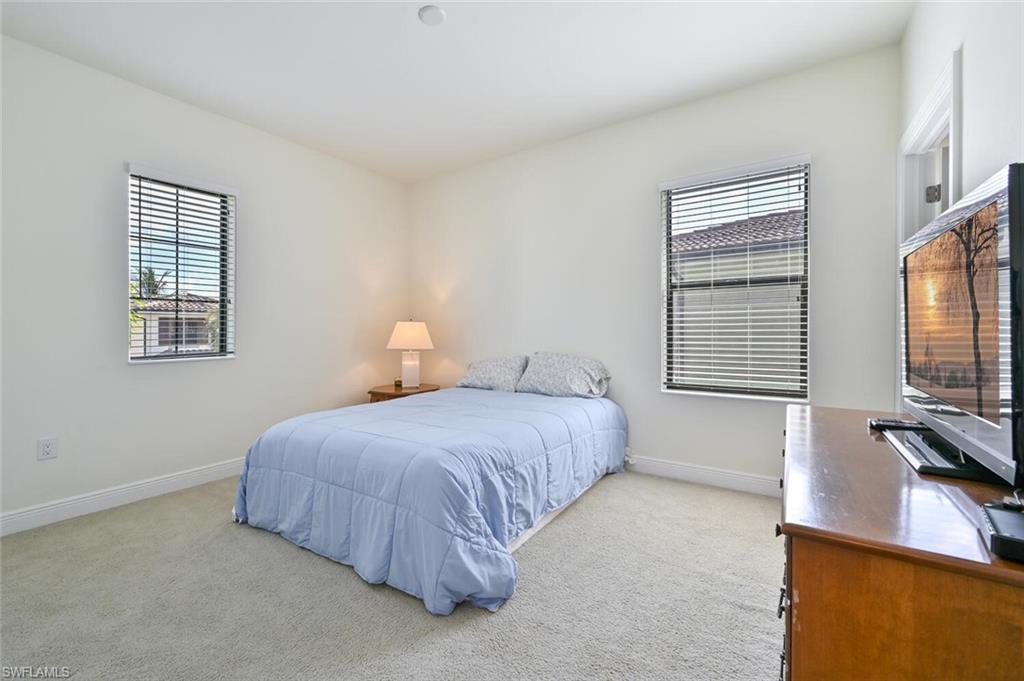 1326 Kendari Terrace Naples, FL 34113 - Photo 19 of 37 a bedroom with a bed lamp on desk and a window