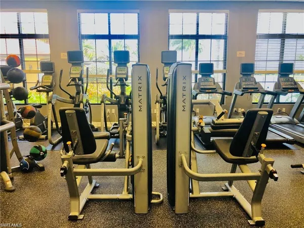 a dining hall with stainless steel appliances kitchen island granite countertop a dining table chairs and a living room view