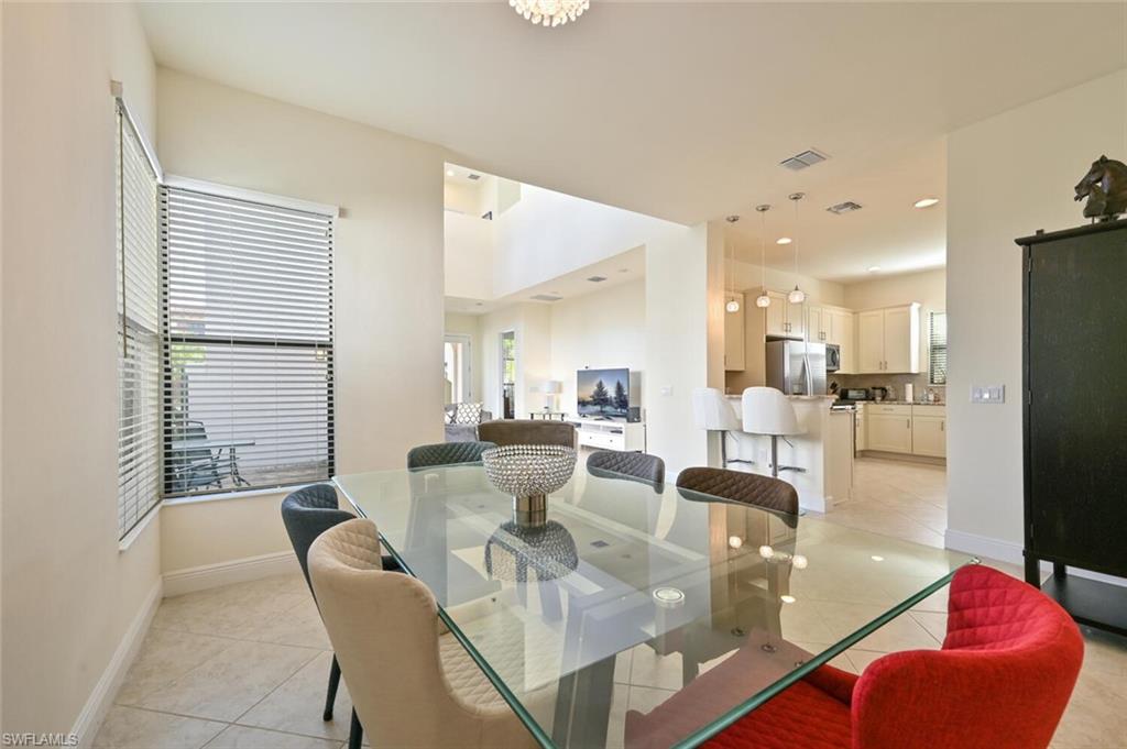1326 Kendari Terrace Naples, FL 34113 - Photo 6 of 37 a living room with furniture dining table and a large window