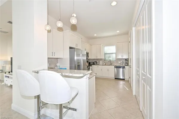 a kitchen with refrigerator cabinets dining table and chairs