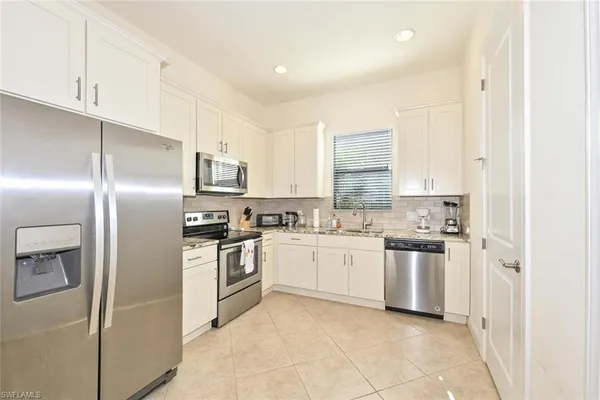 a kitchen with stainless steel appliances granite countertop a refrigerator sink and stove
