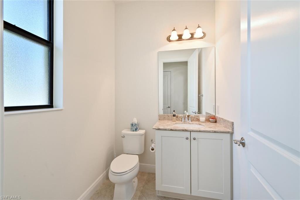 1326 Kendari Terrace Naples, FL 34113 - Photo 10 of 37 a bathroom with a toilet sink and mirror