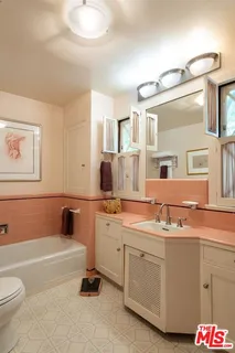 a bathroom with a tub sink and mirror