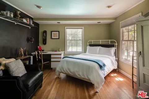 a bedroom with a bed a couch and dresser