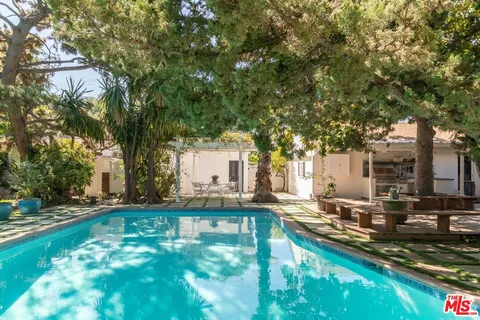 a view of a house with pool and sitting area
