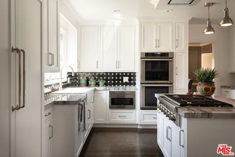 a kitchen with stainless steel appliances a stove a sink and a refrigerator
