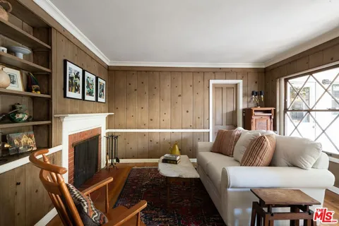 a living room with furniture a fireplace and a large window