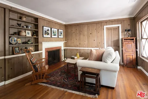 a living room with furniture a fireplace and a wooden floor