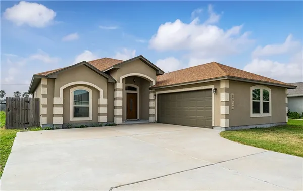 a front view of a house with a yard and garage