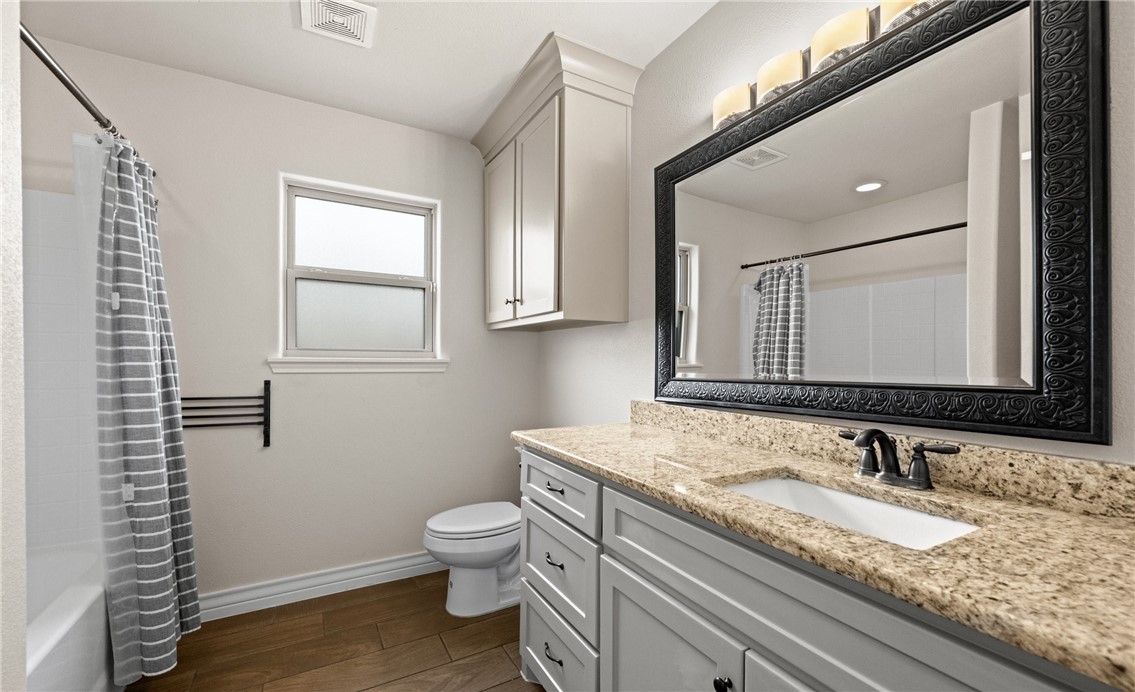 2517 Luzius Drive Corpus Christi, TX 78418 - Photo 19 of 25 a bathroom with a granite countertop sink toilet and mirror