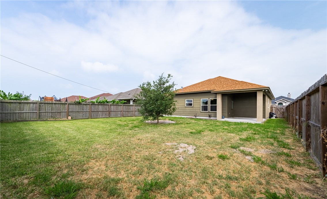 2517 Luzius Drive Corpus Christi, TX 78418 - Photo 25 of 25 a yellow house with a big yard and large trees