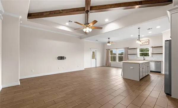 a kitchen with stainless steel appliances granite countertop a refrigerator a sink dishwasher a stove and white cabinets with wooden floor
