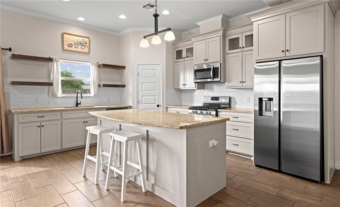 2517 Luzius Drive Corpus Christi, TX 78418 - Photo 8 of 25 a kitchen with stainless steel appliances granite countertop a refrigerator a sink dishwasher a stove and white cabinets with wooden floor