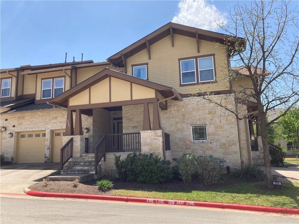 a view of a house with a yard and large tree