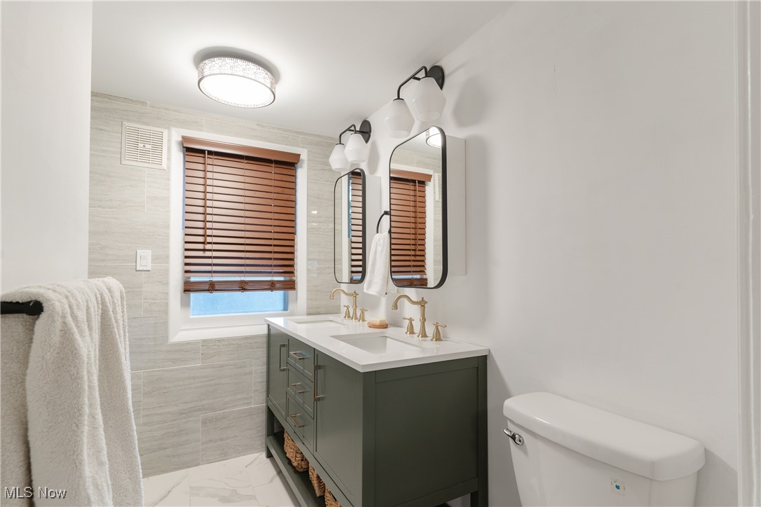 2890 Huntington Road Cleveland, OH 44120 - Photo 18 of 41 Bathroom with tile walls, vanity, and toilet