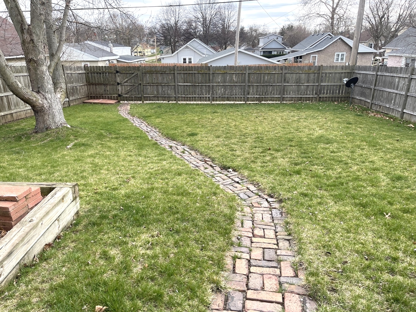 105 West 4th Street Spring Valley, IL 61362 - Photo 14 of 17 a view of a backyard with a large tree and wooden fence