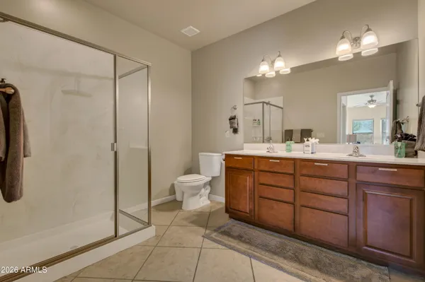 a bathroom with a double vanity sink a toilet and a mirror