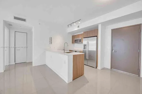 a kitchen with white cabinets and refrigerator