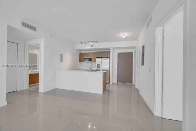 a view of a kitchen with refrigerator and a sink