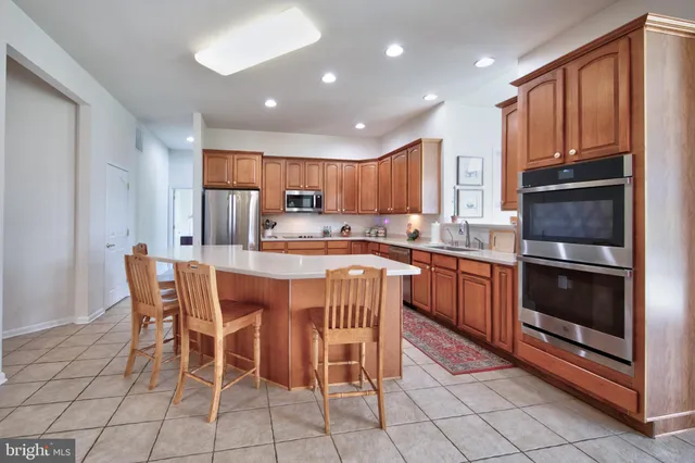 a kitchen with stainless steel appliances granite countertop a stove a sink a microwave and a refrigerator