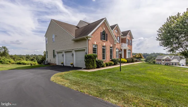 a view of a big house with a big yard and large tree