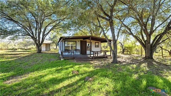 a view of a house with backyard and a tree