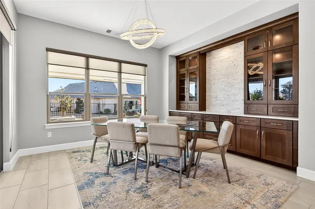a dining room with wooden floor a chandelier a wooden table and chairs