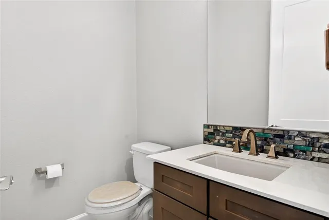 a bathroom with a sink a toilet and mirror