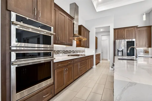 a kitchen with stainless steel appliances kitchen island granite countertop a stove microwave and refrigerator