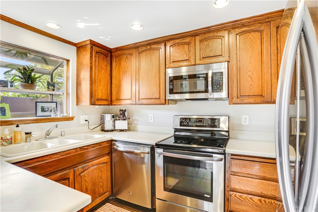 421 Gloucester Drive Costa Mesa, CA 92627 - Photo 10 of 30 Garden window looks out to private rear patio, don't miss the stainless microwave, dishwasher, stove and refrigerator.