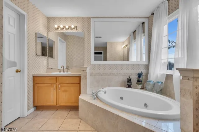 a bathroom with a tub a sink and a mirror