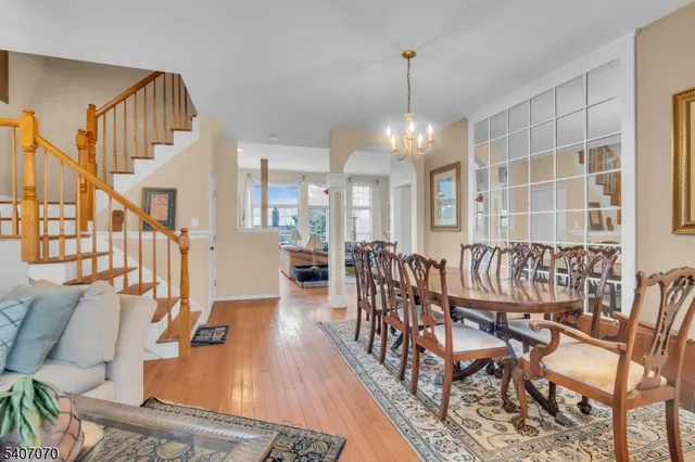 a dining room with furniture a chandelier and wooden floor