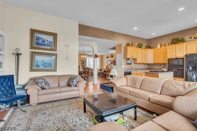 a living room with furniture and a view of kitchen