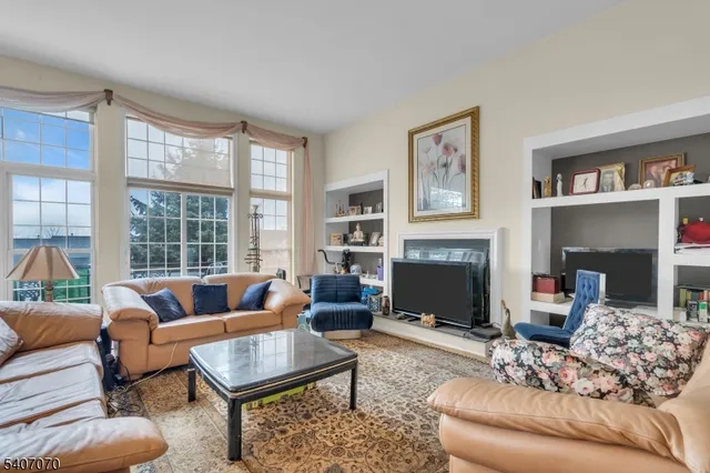 a living room with furniture fireplace and a large window
