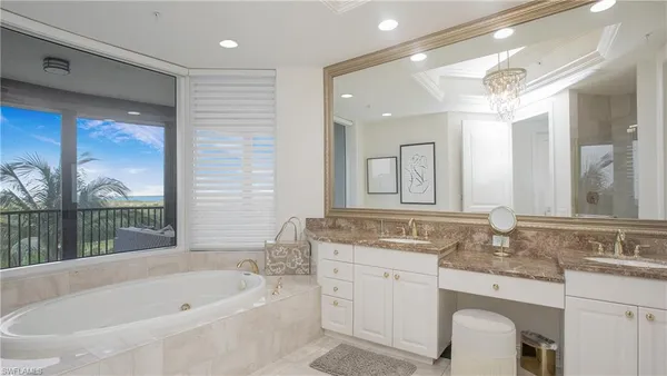 a bathroom with a granite countertop double vanity sink toilet and large mirror
