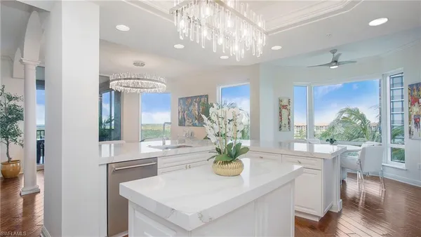 a view of a dining room with furniture a chandelier and wooden floor