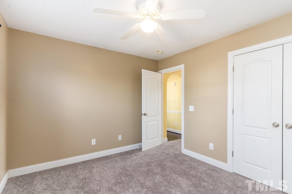 5016 Contender Drive Raleigh, NC 27603 - Photo 6 of 29 an empty room with closet and a chandelier fan