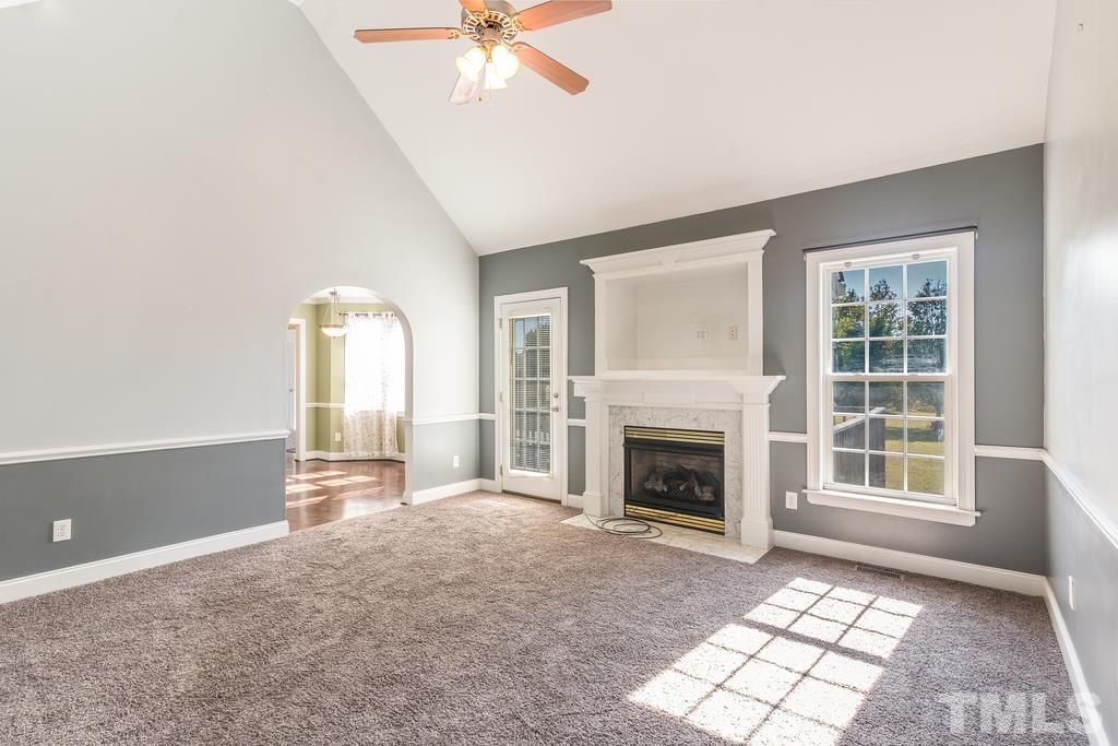 5016 Contender Drive Raleigh, NC 27603 - Photo 10 of 29 an empty room with windows and fireplace